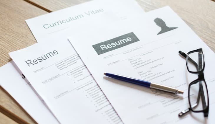 Resume applications on wooden desk ready to be reviewed